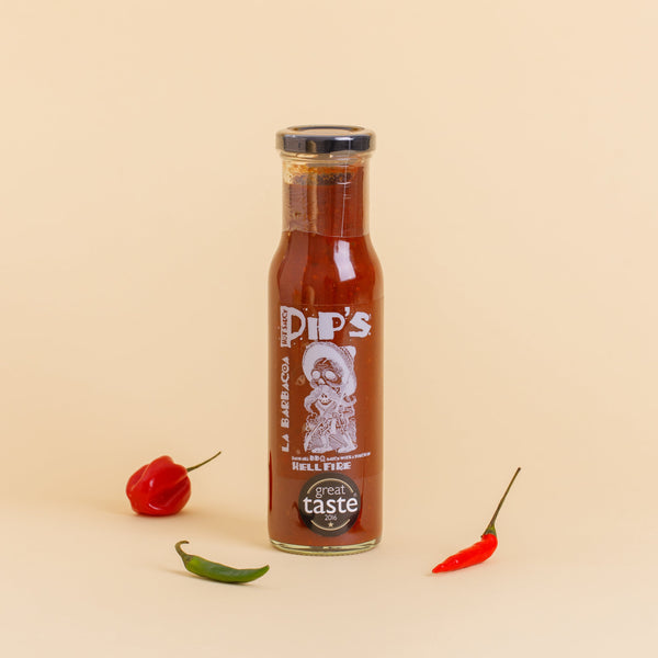 A bottle of "Pip's La Barbacoa Hellfire BBQ Sauce" standing upright on a light beige background. The bottle is surrounded by three colourful chilli peppers—red, green, and orange—highlighting the sauce's deep, smoky flavour. The label displays a skeleton graphic and the "Great Taste 2016" award.